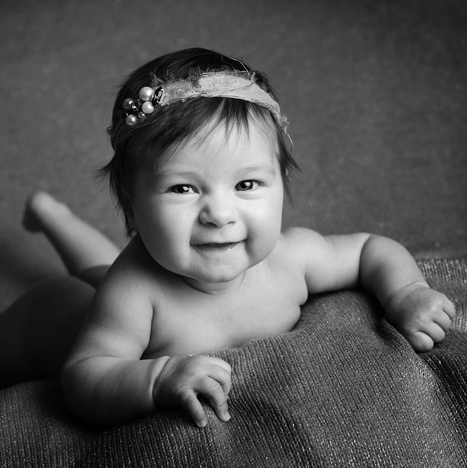 photo bébé nu sur le ventre qui sourit