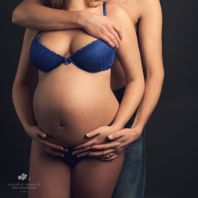 photo de couple femme enceinte et homme enlaçés mains sur le ventre