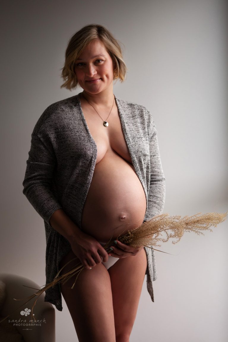 photo grossesse femme enceinte chez elle avec un gilet long