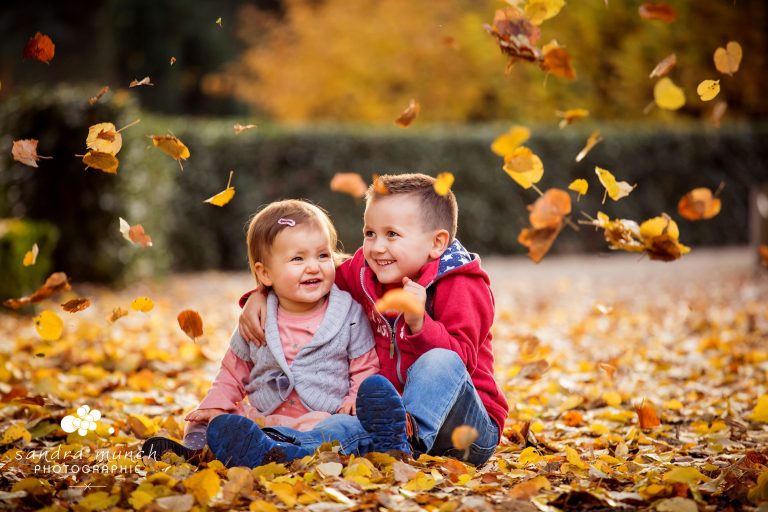 photo d'enfants jouant dans les feuilles d'automne