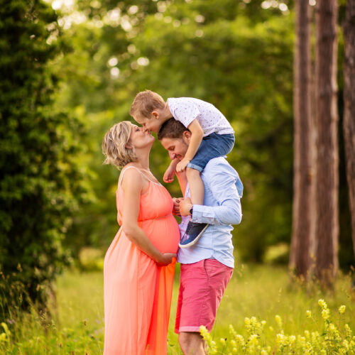photo de parents et enfant dans la nature qui s'embrassent