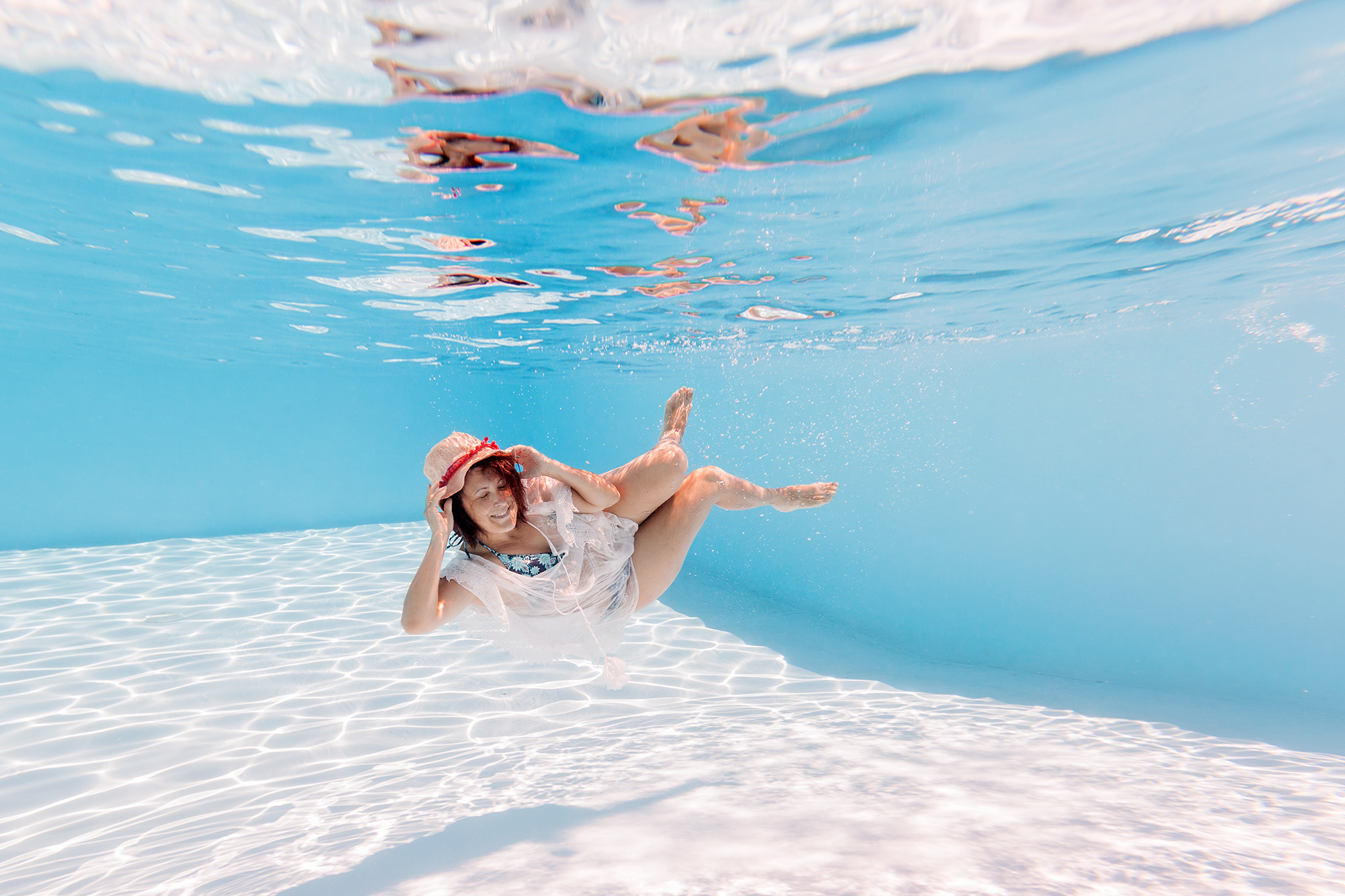 photo femme habillée au fond d'une piscine