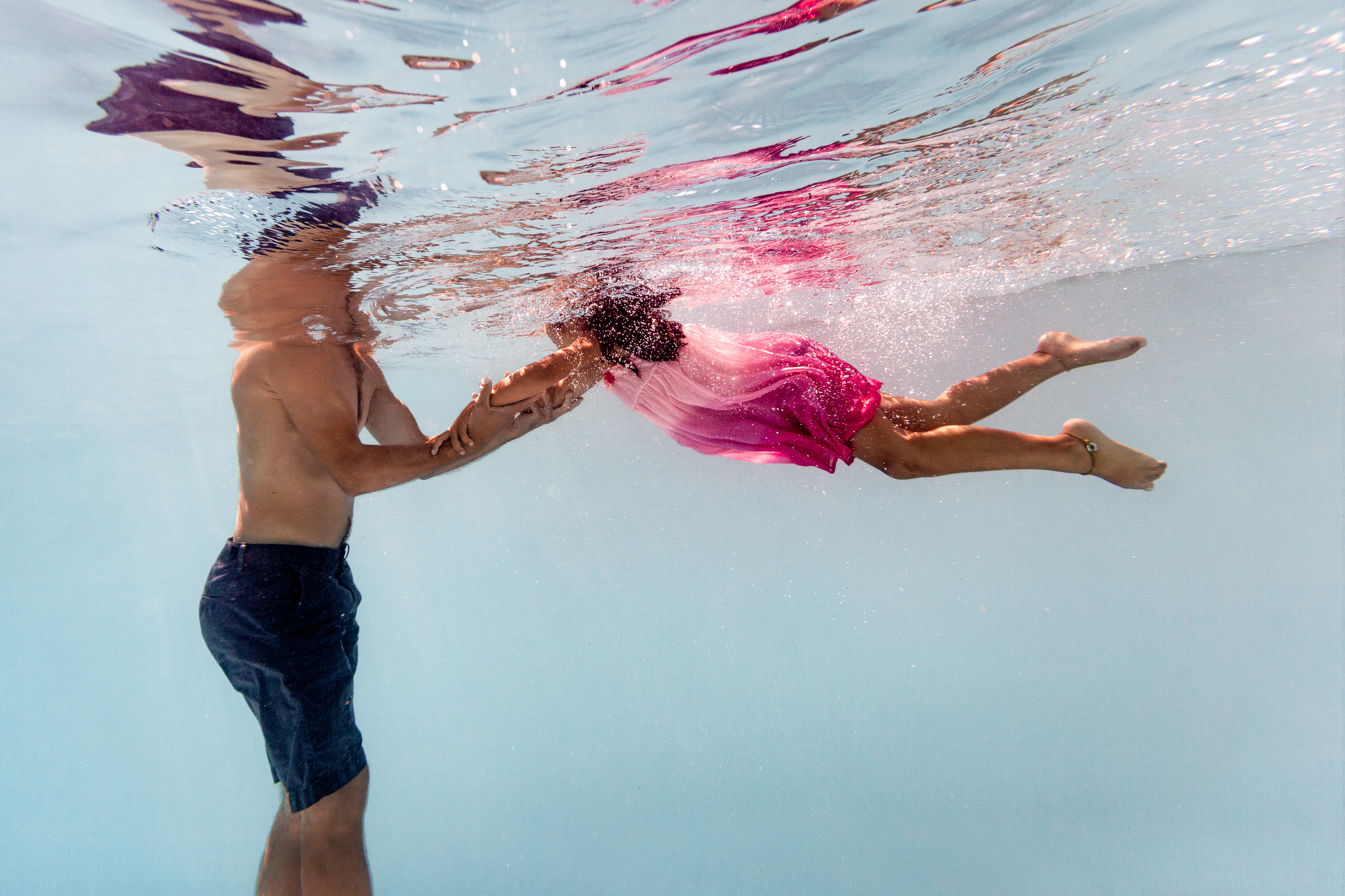 photo de famille sous l'eau avec enfant qui nage vers son papa
