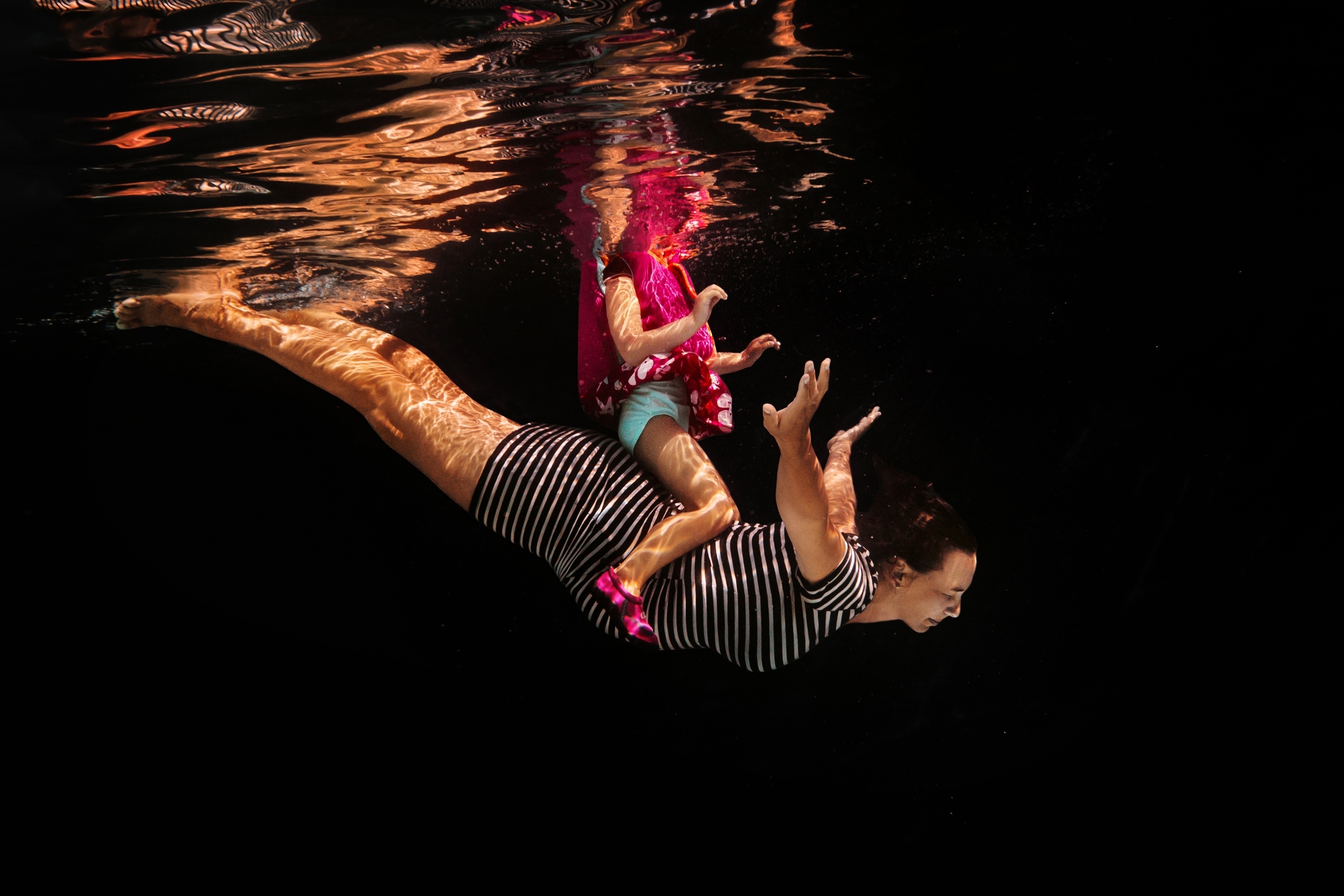 photo aquatiques maman enceinte et bébé sur son dos avec gilet de sauvetage