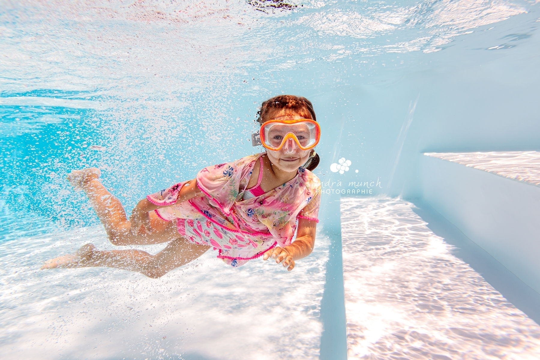 séance photo underwater d'un enfant qui sourit sous l'eau