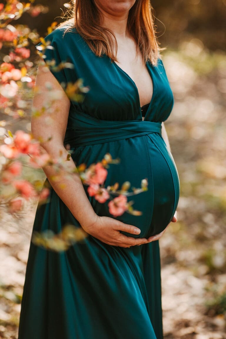 Future maman en robe élégante vert foncé pour photos à Molsheim