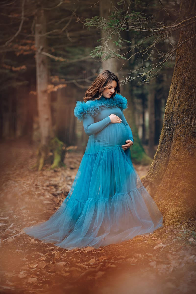 Future maman en robe bleue et jupon très élégante en forêt à Klingenthal