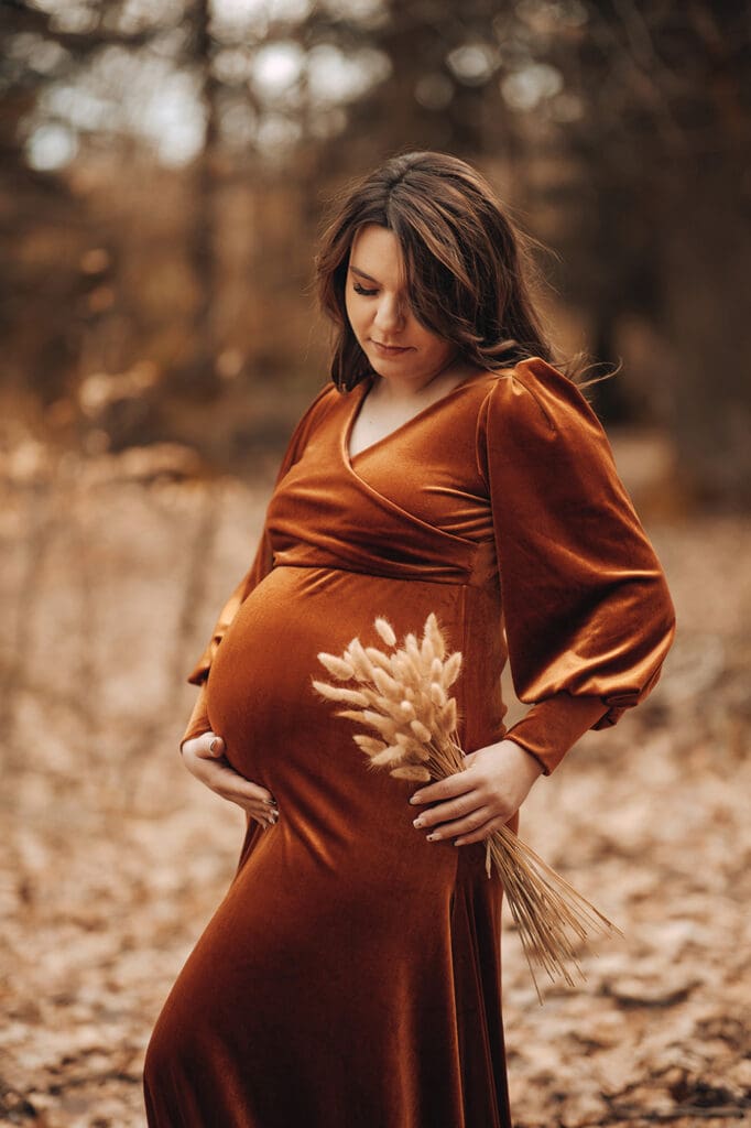 Future maman en robe de velours dorée et chaude pour séance photo automne/hiver dans la forêt en Alsace