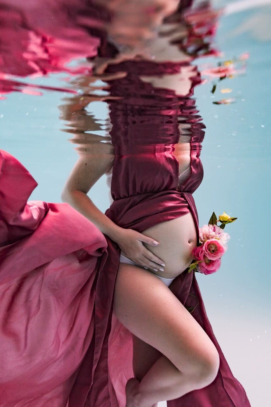Femme enceinte sous l'eau en robe de satin rose foncé à Lingolsheim