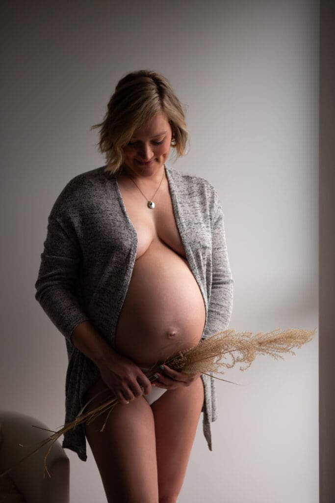 Séance photo grossesse à domicile en Alsace, future maman debout dans la chambre du bébé